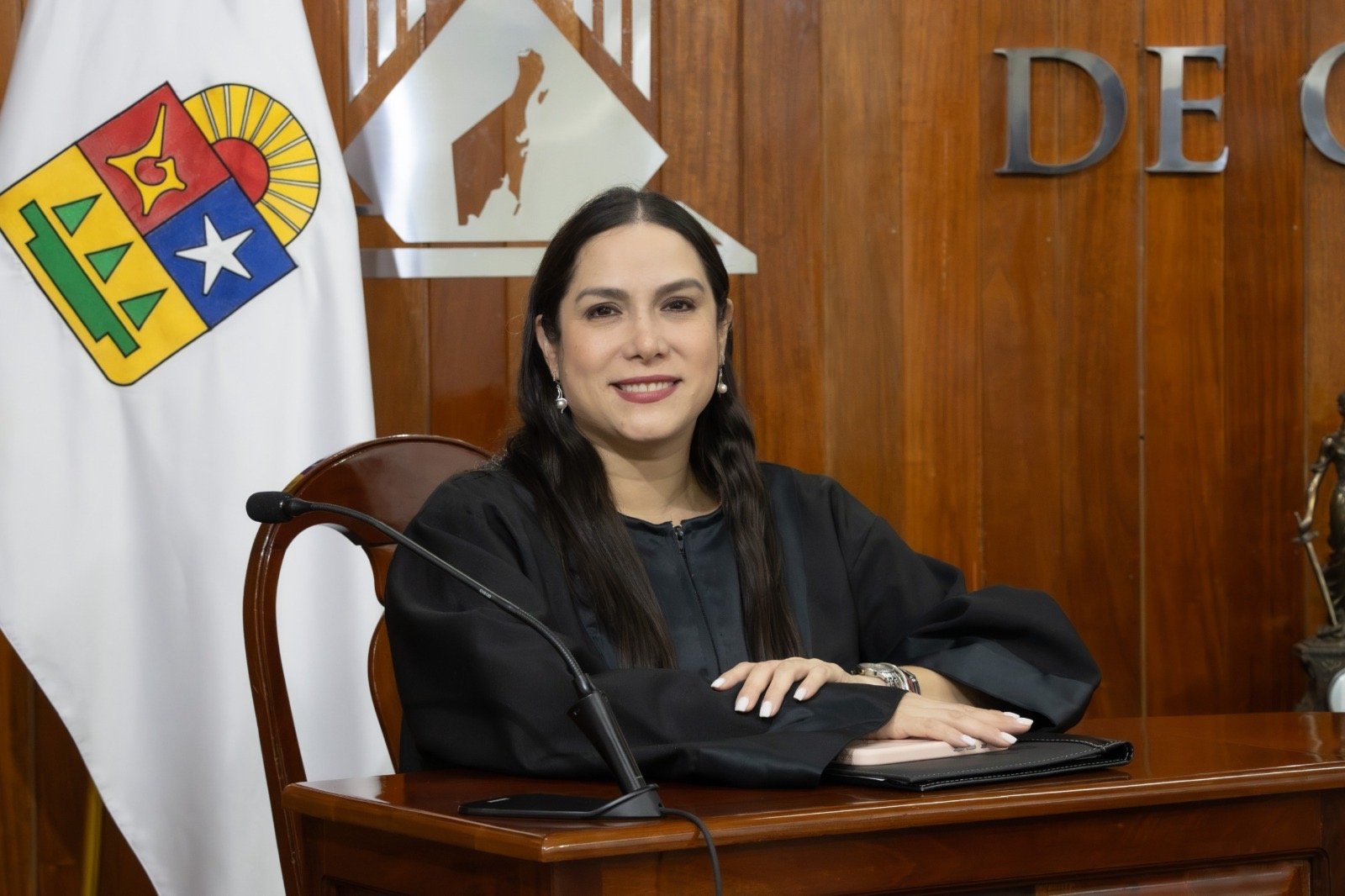 Magistrada en la sala del Tribunal Electoral de Quintana Roo, junto a la bandera estatal.