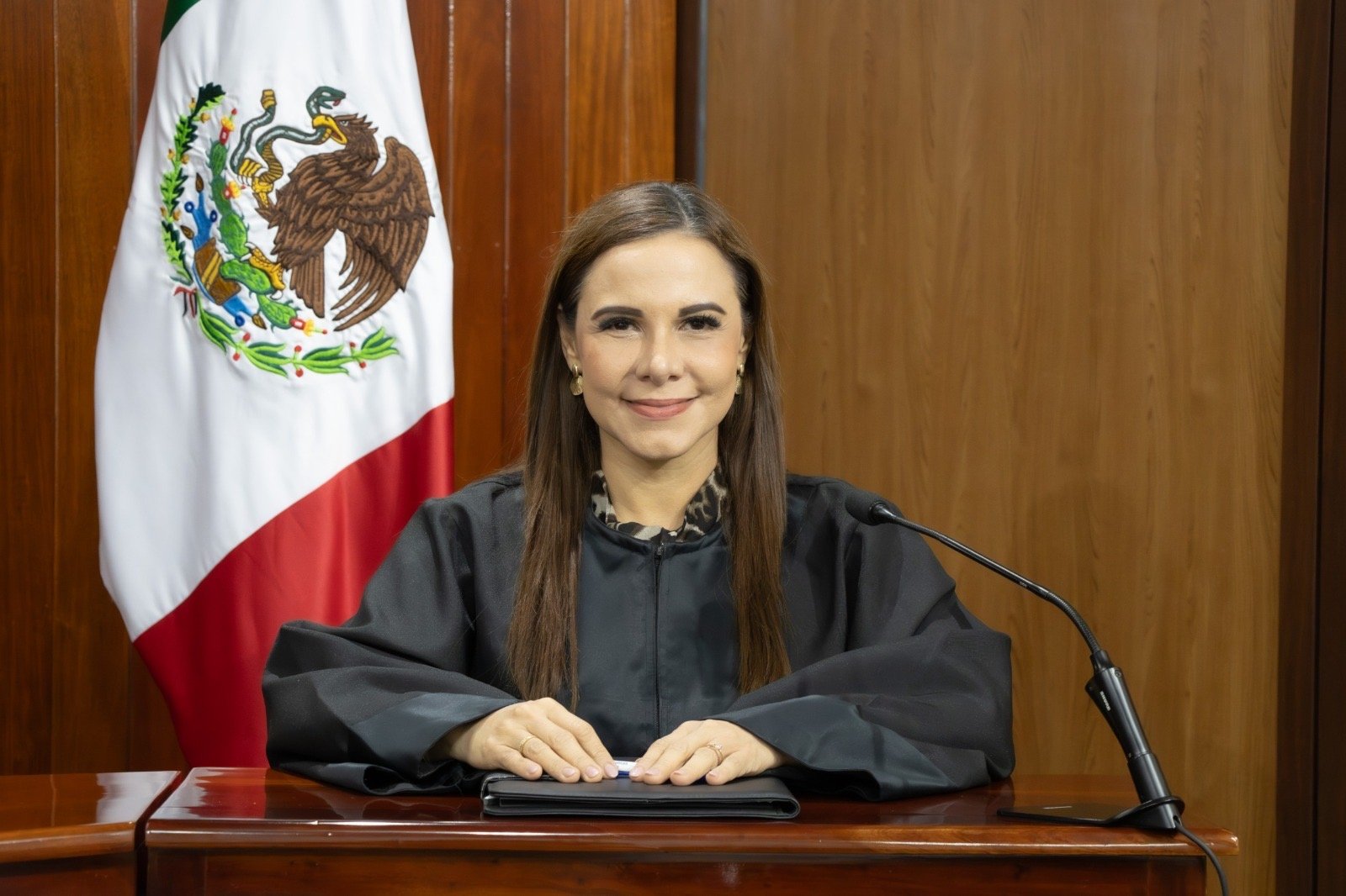 Magistrada en la sala del Tribunal Electoral de Quintana Roo, junto a la bandera nacional.